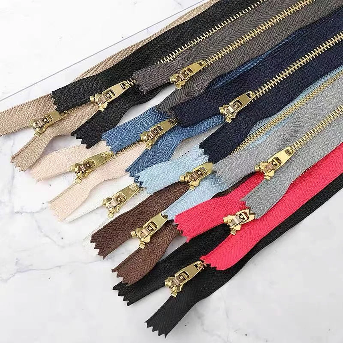 Metal zippers with gold-tone teeth and multiple tape colors