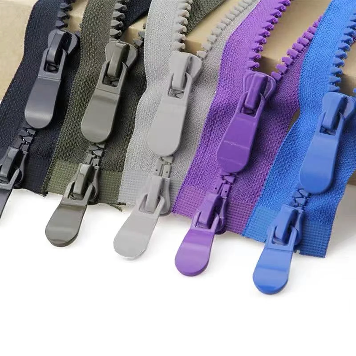 Plastic molded zippers in black, green, grey, purple and blue